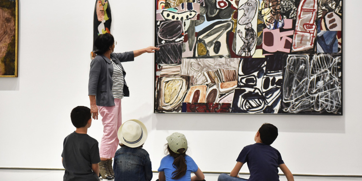 Une médiatrice et des enfants regardant une oeuvre de Dubuffet