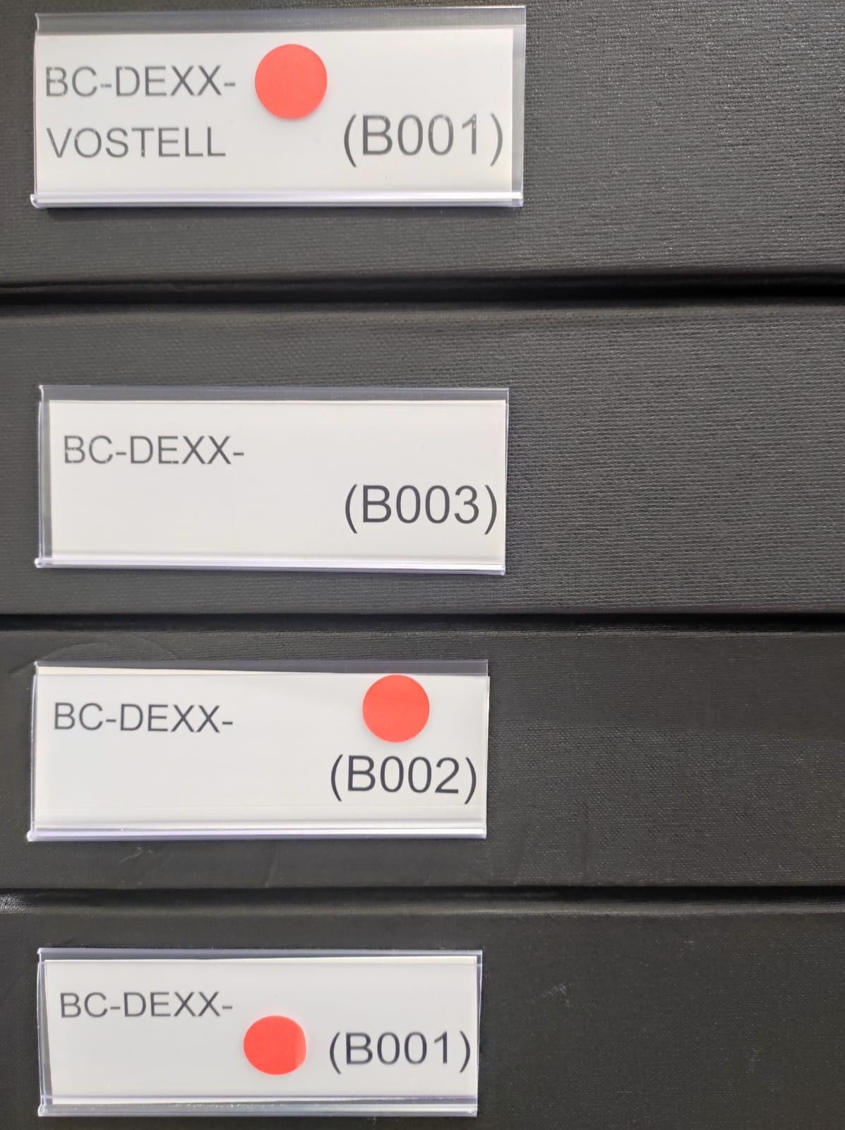 Étiquettes sur boites de conservation pour des dessins de la collection du MAMC+. Les gommettes rouges indiquent que le récolement des œuvres a été réalisé.